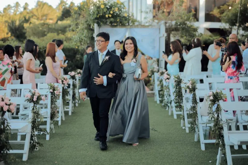 Groom and bride walking down the aisle with gray elegant gown